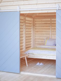 Designed by Linda Bergroth, the spruce timber structures are meant to evoke the simple pleasures of <i>aitta</i>, traditional Finnish country houses.