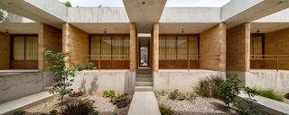 An Eco-Friendly Getaway Built With the Future in Mind - Photo 3 of 7 - The materials—concrete, stone, and brick—reference the local architecture, tying the house to its site and making it easier to find a construction team.