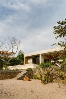 An Eco-Friendly Getaway Built With the Future in Mind - Photo 4 of 7 - The concrete-and-brick house is perched on a stone wall. 
