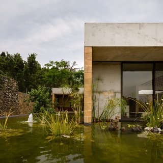 An Eco-Friendly Getaway Built With the Future in Mind - Photo 1 of 7 - Located outside of Mexico City, Casa GP by architecture firm Ambrosi | Etchegaray integrates the local landscape with features like this pond.