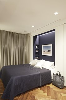 The Murphy bed niche is lined in deep blue fabric by KnollTextiles, one of the few pops of color in the space. 