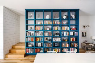 Sustainability is the Centerpiece of This New Austin Development - Photo 5 of 6 - A blue book case adds a bit of color to the bright interior. Buyers of the Tilley row houses were able to customize the interior finishes including native Texas pecan flooring. 