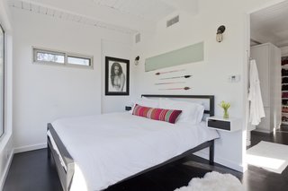 The couple's minimalist bedroom was imagined like a suite in a boutique hotel. There is a bedroom, closet, and bathroom, but minimal furniture as to avoid cluttering the bright white space. 