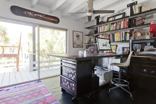 The office is filled with personal projects. Chad built the desk using Husky utility cabinets. A photograph from a photoshoot he did with Lil Wayne is printed on the work surface.