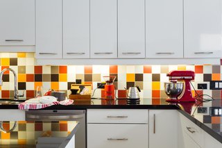 The backsplash is an exuberant mix of colorful tile. "We used a randomizer algorithm to design the multi-colored non-pattern," says Lori. 
