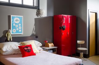 A red gym locker, repurposed as storage, is a whimsical touch in the bedroom.