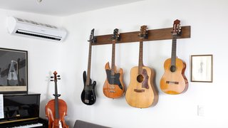 Composer and podcaster Hrishikesh Hirway hangs guitars and a bass from wall mounts in his Eagle Rock studio to conserve space.