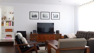 The living room is outfitted with a Petrie sofa from Crate & Barrel and a leather love seat from Room & Board. The armchair and console are vintage. 