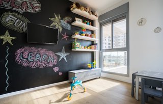A chalkboard wall encourages creative exploration in the child’s room. 