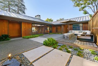 A Quintessential Midcentury Home Goes LEED Platinum - Photo 1 of 5 - Shannon Bloemker’s hillside home in Piedmont, California, is arranged in a C-shape with a protected courtyard landscaped by Gardener’s Guild. The fire pit is by Spark Linear Burner.