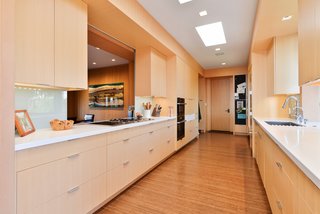 A Quintessential Midcentury Home Goes LEED Platinum - Photo 3 of 5 - Bloemker calls the original kitchen, which included such Space Age wonders as built-in can openers, an "afterthought," disconnected from the rest of the home. Architect Michelle Kaufmann set about removing walls to open up the space. The countertops are Caesarstone; the maple cabinetry is by Randall Wilson & Sons Fine Carpentry.