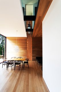 Is it Any Surprise a Sculptor Had a Hand in This Home? - Photo 1 of 4 - A textured wood walls meets a glass cutaway on the second floor. The Wishbone chairs are by Hans Wegner. 
