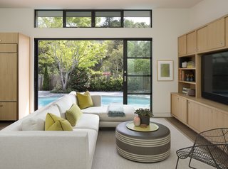 A New Spin on the Suburbs in Marin - Photo 1 of 4 - Sliding glass doors connect this renovated home in Marin County to a rear terrace and kidney-shaped pool. The sectional sofa is custom by Mansfield + O’Neil Interior Design. 