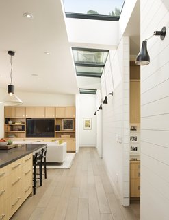 A New Spin on the Suburbs in Marin - Photo 3 of 4 - A painted wood wall marks the boundary between the home’s public and private wings. Linear skylights bathe the open-plan communal area in light. 