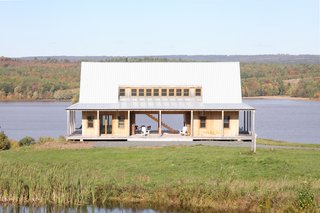 Architects Antje Freiesleben and Johannes Modersohn combined two barn-like wings and a large connecting hall/breezeway for a retreat in New Brunswick. A space between the concrete foundation and the house’s raised wood platform allows the snowmelt to pass through in spring. The 21-foot-wide accordion doors are by HFBB Holzfensterbau Bernau and were shipped from Germany.