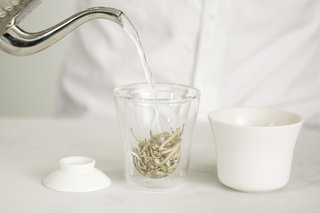 The design is made up of three components: the double-walled borosilicate glass cup with a slip-cast porcelain ceramic bowl and lid. Once the tea is ready, the lid can be pulled back to pour, no strainer required. 