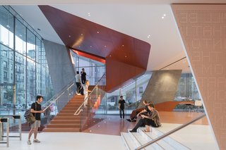 The lobby features seating and a cafe with views overlooking the courts. 