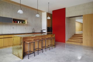 The other centenarian fixtures in the home are the glass light shades in the kitchen. The shades originally hung in an old chapel. The brass bar was designed by the firm. 