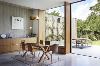 50 Modern Homes With Floor-to-Ceiling Windows - Photo 38 of 50 - Seeking a home away from the city, architect Jake Edgley found a former fruit orchard outside of London in Dulwich for his family to plant their own roots. The land had grown wild with trees so Edgley and his practice, Edgley Design, relied on channeling the site's history to guide the design. Built around a 100-year-old pear tree, the modern courtyard home takes full advantage of its surroundings, from the vertical wood boards to filling the home with natural light throughout the day. 