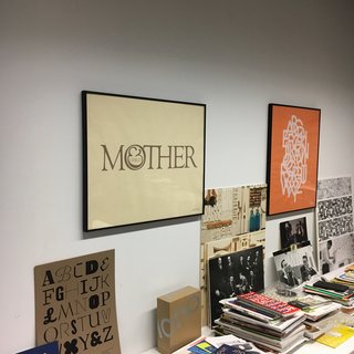 New York's Hidden
Graphic Design Gem - Photo 3 of 6 - Shot taken within the Herb Lubalin Study Center the original "Mother & Child" logo, to the right "ABCDEFG..." the alphabet set in Avant Garde Gothic, designed by Herb Lubalin and Tom Carnase. One of many examples of typically Lubalin-esquen arrangement of interlocking and overlapping letterforms. 1974