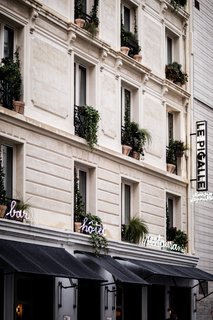 The neo-classical building that houses Le Pigalle is done in the local Parisian style known as La Nouvelle Athènes and features conic moldings and friezes. The neon signs that adorn the exterior reference the frequent use of neon throughout the Pigalle neighborhood. 