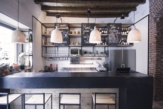 Bringing a Taste of
Sicily to Milan - Photo 2 of 5 - Studio DiDeA designed the bar stools and shelving units and had them manufactured in Sicily by local artisans. Chalkboards on the shelving units list menu options and daily specials. 