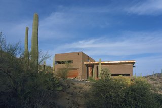 These 7 Homes in the Southwest Show How to Design For the Desert - Photo 5 of 7 - Three pavilions of masonry, rusted steel, and glass come together in Tucson, Arizona, to create a home designed by Ibarra Rosano Design Architects that draws inspiration from the desert landscape. Each facade is in direct response to the sun, wind, topography, vegetation, and views. Windows are long and shaded, entryways are covered, and views are curated to capture indirect sunlight and provide vistas of the landscape beyond.