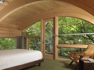 Casey Key House<br><br>In this playful treehouse-style bedroom, custom arched windows surround the room and meet the wooden ceiling. Elements of wood and modern architecture draw the sound of rustling leaves and midday breeze into this cozy treetop retreat.<br><br>Architect: Jerry Sparkman; Architecture Firm: Sweet Sparkman Architects