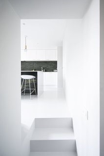 Niels & Annemie is a minimal residence located in Brussels, Belgium, designed by Benoît Deneufbourg and la fabrika studio. The design brief was clear; Niels and Annemie wanted to keep the classical ‘Hausmann grandeur’ (high ceilings, large rooms, white walls, wooden floors) and combine this with modern lines and materials. The design approach was to keep it simple by using a black and white color scheme as the basis throughout the apartment. Their collection of Scandinavian and Italian furniture mixed with some original vintage pieces complements this refined interior, effortlessly blending old and new. 