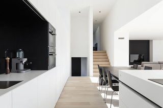 Home DW is a minimal house created by Belgium-based designer Francisca Hautekeete. From every floor of the house you can look across to the other floors crosswise. Split levels were utilized to create several zones in compact housing. The living space of the split-level house sits centrally on the middle floor from which several steps lead to other levels: the home office on the ground floor and a children’s room on the top floor. The music room was an indispensable part, hidden behind a closet door.