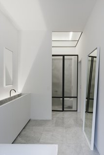 House F Antwerp is a minimal residence located in Antwerp, Belgium, designed by Hans Verstuyft Architecten. Their work is based on the specific conditions each project has. The result is an analysis of these conditions: program, surroundings, budget, users, light; but also more subjective elements like feeling, warmth, comfort, touch, sensuality. They wanted to include in the project a way of life, and not only a rational solution. The space features large lightwells that provide abundant natural lighting to the staircase as well as for the kitchen and dining area.