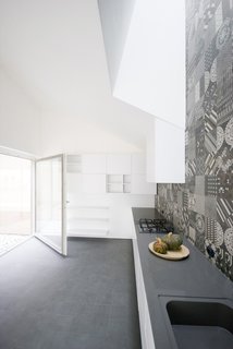 Wigglyhouse is a single-family residential building located in a difficult context 50km away from Milan in Italy, characterized by multi-storey buildings that surround it. The covering reaffirms this principle. Canadian gray granite covers the entire building to symbolize this idea of protection with the exception of the walls where the volume is subtracted by the grey-plaster made patios. The pitches of the roof alternate, "wiggling" the sequence of the lines of the roof section.