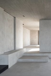 C Penthouse is a minimal space located in Antwerp, Belgium, designed by Vincent Van Duysen. The concept of the project was to create an ‘urban loft’. The concrete ceiling and rough timber refer to the historical warehouses which have an architectural presence in the surrounding quay and the city. The spacious and volumetric approach is inspired by the abstract and Cubist artwork of Georges Vantongerloo, an Antwerp artist and cofounder of the art movement De Stijl. The project uses strong architectural sensitivity and qualities in a residential apartment context. The sculptural architectonic approach corresponds to the abstract expressionist art collection of the owner. The walls and floor are finished in the same material to rigorous detail as this results in a sober and textural appearance. The material selection is a manifestation of the gray tones of the Schelde and its quayside, as well referring to the Arte Povera movement where driftwood, metal, earth and concrete were used.