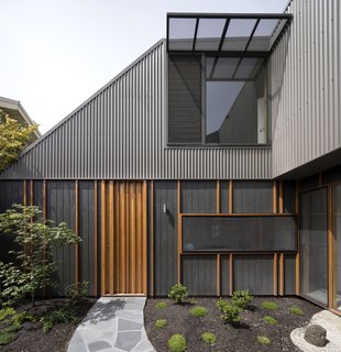 Although the property looks like a one-story home from the street, its second level is more noticeable from the enclosed courtyard. Blackbutt vertical battens provide texture to shadowclad exterior plywood with an Onyx Quantum Aquaoil finish. 