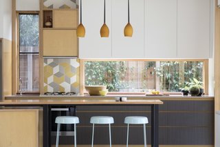 Gewinn pendant lights match the woodwork in the kitchen. Urban Edge's Mutina "Tex" Splashback tiles add a graphic element against Flexipanel cupboard doors painted in "Parchment Matte."