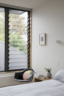 A Breezway Louver window brings fresh air into a bedroom. "Despite their modest size, all spaces feel expansive, thanks to the constant presence of generous windows," Porjazoski says. 