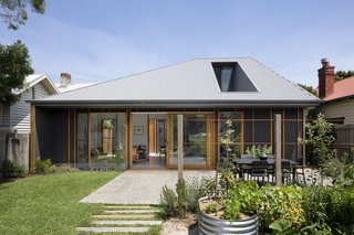 Retaining as much of the backyard as possible was a necessity, since the homeowners enjoy gardening. An exposed aggregate concrete deck and hardwood sleeper paths bring some of the home's materials into the open space.