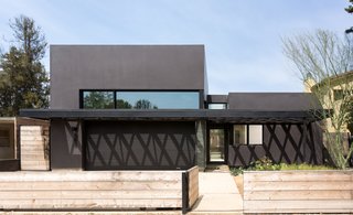 Benjamin Moore's "Universal Black" distinguishes the exterior from the unfinished spruce fence. 