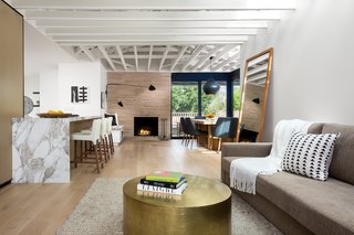Custom white oak by Contempo Floor Coverings spreads across the floor in the open living area. Malibu Market and Design supplied the metal coffee table, and the rug was purchased from Restoration Hardware. 