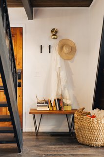 A 1970s A-Frame Cabin in Big Bear Is Brought Back to Life - Photo 3 of 12 - Four hooks and a bench, both from CB2, create a small, dedicated entryway next to the front door. 