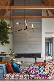 "The owner wanted some part of the house to be more cozy, and the vibrantly colored Roche Bobois sofa did the trick," Posno says. Bell Side Tables by Sebastian Herkner and a Coltrane suspension ceiling lamp by DelightFULL complete the look. 