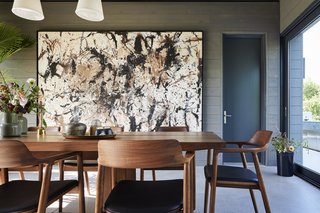 Interior design firm & Daughters built the dining table, and the Hiroshima upholstered dining chairs are by Naoto Fukasawa from Mjölk. Harouna Ouedraogo artwork hangs on the wall.