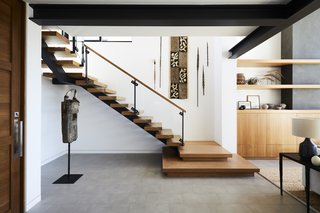 The staircase was moved to be more prominently featured in the home's renovation. The owners' surrounding art collection makes it even more striking. 