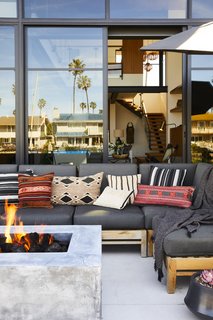 "The home is special because it feels curated, but very personal," the interior designer says. "The owners had a hand in every part of the process." The colors in the outdoor space match those found inside, including the red lumbar pillow from Amber Interiors that's also in a bedroom. 