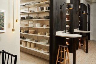 The tables on the ends of the storage aisles can be workspaces for employees, thanks to power outlets and USB plugs. 
