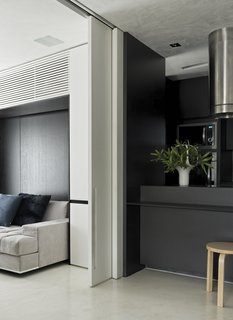 A sliding door to the guest bedroom makes this flexible area even more accessible. A burnt cement floor connects this room to the kitchen. 
