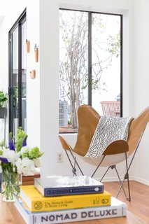 A Venice Beach Abode Becomes a Chic Coliving Space Where Everything's For Sale - Photo 3 of 7 - The butterfly chair in the living room was sourced from Urban Outfitters, and books rest on Article nesting tables. 