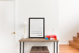A Venice Beach Abode Becomes a Chic Coliving Space Where Everything's For Sale - Photo 4 of 7 - The entryway is minimal yet stylish, thanks to location-specific artwork and a couple of brightly covered books. 