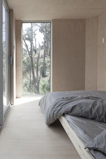 This Off-Grid Container Home in Australia Disappears in Nature - Photo 6 of 8 - Since artwork was passed over for the beauty of the outdoors, windows create light and movement in the two bedrooms. 