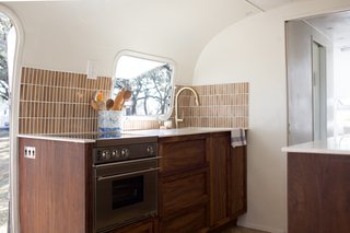  The kitchen epitomize's Oliver's balance of needs and wants. There are soft-close drawers—a cool <i>want—</i>but also a refrigerator and freezer that use AC or DC power. "It can run off the batteries and stay cold all the time, even while the Airstream is in transit." Now, that's a fun <i>need</i>. 